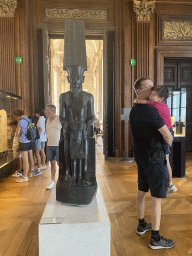 Tim and Max with the statue of the God Amon protecting Pharaoh Tutankhamun at the First Floor of the Sully Wing of the Louvre Museum, with explanation