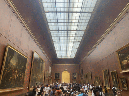 Paintings at the First Floor of the Denon Wing of the Louvre Museum, with a view on the statue `Winged Victory of Samothrace` at the Daru Staircase