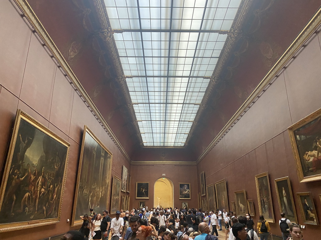 Paintings at the First Floor of the Denon Wing of the Louvre Museum, with a view on the statue `Winged Victory of Samothrace` at the Daru Staircase