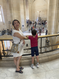 Miaomiao and Max at the First Floor of the Denon Wing of the Louvre Museum, with a view on the statue `Winged Victory of Samothrace` at the Daru Staircase