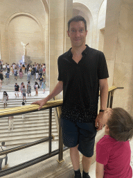 Tim and Max at the First Floor of the Denon Wing of the Louvre Museum, with a view on the statue `Winged Victory of Samothrace` at the Daru Staircase