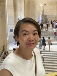Miaomiao at the First Floor of the Denon Wing of the Louvre Museum, with a view on the statue `Winged Victory of Samothrace` at the Daru Staircase