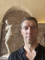 Tim in front of the statue `Venus de Milo` at the Parthenon Room at the Ground Floor of the Sully Wing of the Louvre Museum