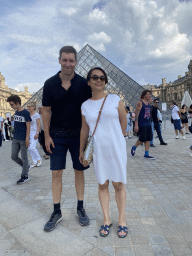 Tim and Miaomiao in front of the Louvre Pyramid and the Sully Wing of the Louvre Museum at the Cour Napoléon courtyard