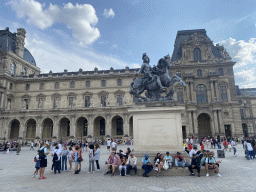Equestrian statue of King Louis XIV in front of the Denon Wing of the Louvre Museum at the Cour Napoléon courtyard