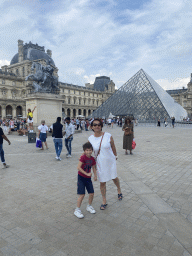 Miaomiao and Max in front of the equestrian statue of King Louis XIV, the Louvre Pyramid and the Richelieu and Sully Wings of the Louvre Museum at the Cour Napoléon courtyard