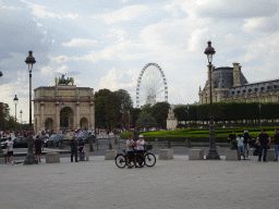 The Place du Caroussel square with the Arc de Triomphe du Carrousel, the Tuileries Gardens with the Ferris Wheel and the Marsan Wing of the Louvre Museum, viewed from the Cour Napoléon courtyard