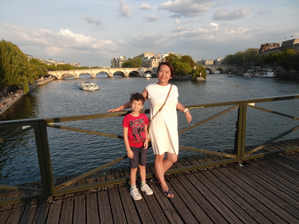 Miaomiao and Max at the Pont des Arts bridge over the Seine river, with a view on the Pont Neuf bridge and the Île de la Cité island