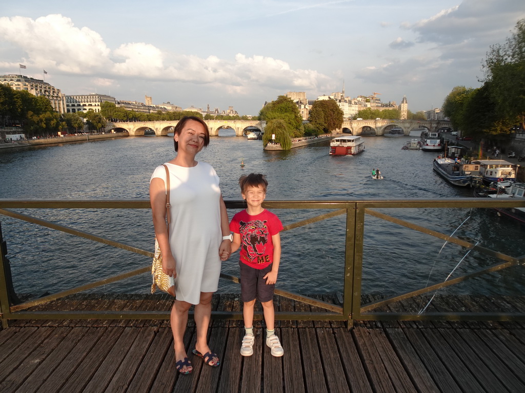 Miaomiao and Max at the Pont des Arts bridge over the Seine river, with a view on the Pont Neuf bridge and the Île de la Cité island