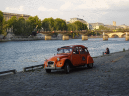 Old Citroën 2CV car at the Promenade Marceline Loridan-Ivens, with a view on the Pont des Arts bridge over the Seine river