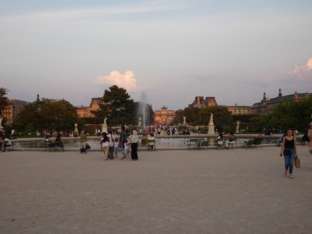 Fountain at the Grand Bassin Rond pond at the Tuileries Gardens, the west side of the Arc de Triomphe du Carrousel at the Jardin du Carrousel garden and the Louvre Museum