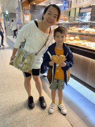 Miaomiao and Max with bread in front of the Paul bakery at the La Défense railway station