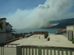 The Bay of Kotor and smoke from a forest fire near the town of Njivice, viewed from the tour bus on the E65 road at the town of Herceg Novi