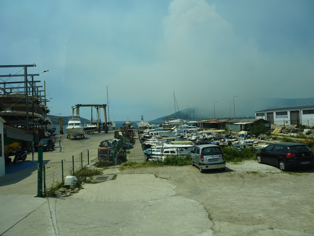 The Zelenika Harbour and smoke from a forest fire near the town of Njivice, viewed from the tour bus on the E65 road