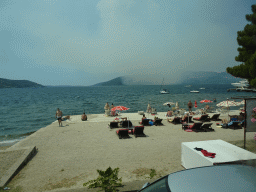 The Zmijica Beach at the town of Zelenika and smoke from a forest fire near the town of Njivice, viewed from the tour bus on the E65 road