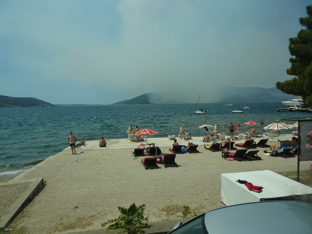 The Zmijica Beach at the town of Zelenika and smoke from a forest fire near the town of Njivice, viewed from the tour bus on the E65 road