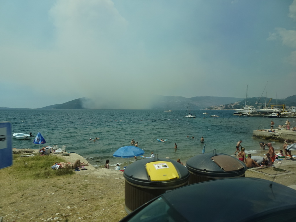 The Zmijica Beach at the town of Zelenika and smoke from a forest fire near the town of Njivice, viewed from the tour bus on the E65 road