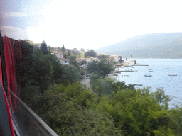 Boats at the Bay of Kotor and houses at the town of Kumbor, viewed from the tour bus on the E65 road