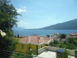 Boats at the Bay of Kotor and houses at the town of Ðenovici, viewed from the tour bus on the E65 road