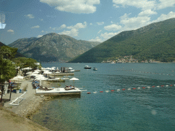 Boats at the Bay of Kotor, beach at the town of Kamenari and the town of Perast, viewed from the tour bus on the E65 road