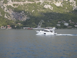 Boat at the Bay of Kotor and the town of Lipci, viewed from the tour bus on the E65 road at the town of Kostanjica