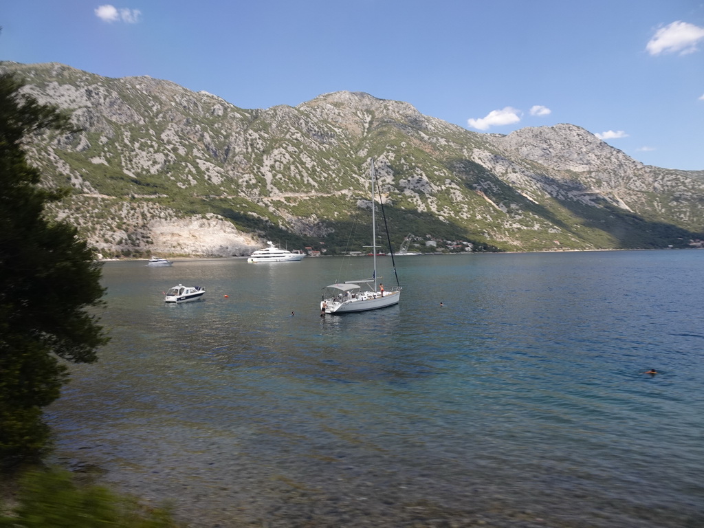 Boats at the Bay of Kotor and the town of Lipci, viewed from the tour bus on the E65 road at the town of Kostanjica