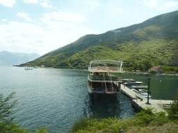 Boats at a pier at the town of Morinj and the Bay of Kotor, viewed from the tour bus on the E65 road