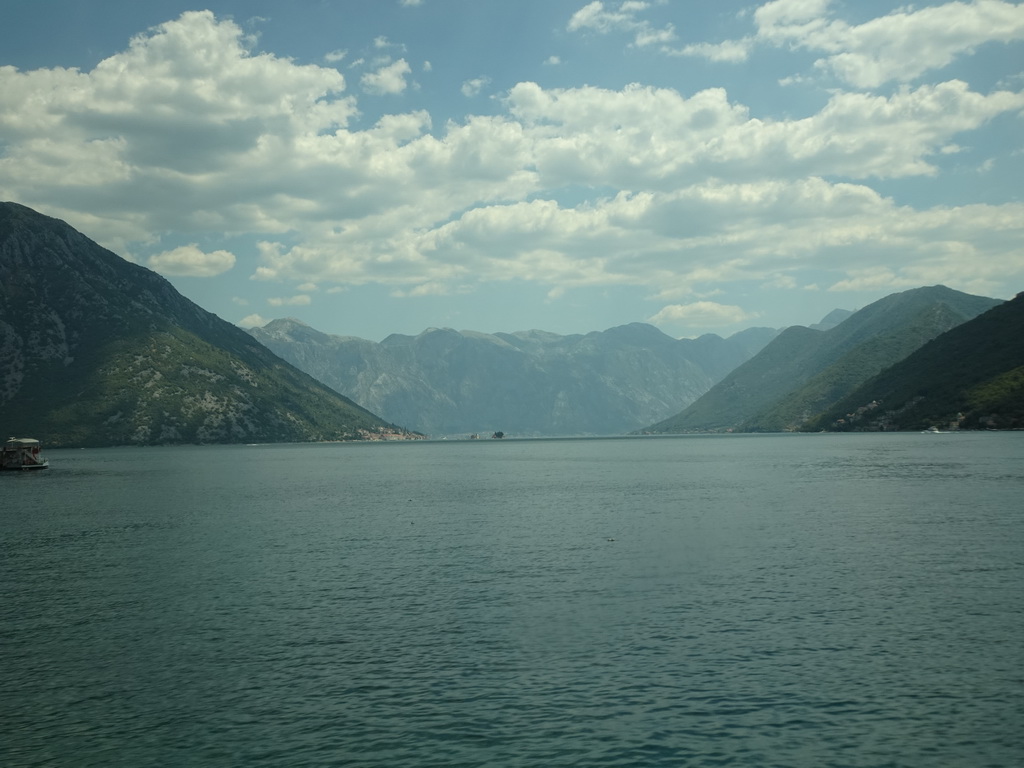 Boat at the Bay of Kotor with the Our Lady of the Rocks Island and the Saint George Island and the town of Perast, viewed from the tour bus on the E65 road at the town of Morinj