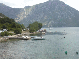 Boats at a pier at the town of Strp and the Bay of Kotor, viewed from the tour bus on the E65 road