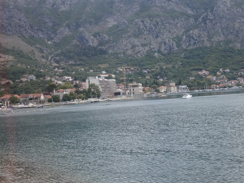 Beach at the town of Risan and boats at the Bay of Kotor, viewed from the tour bus on the E65 road