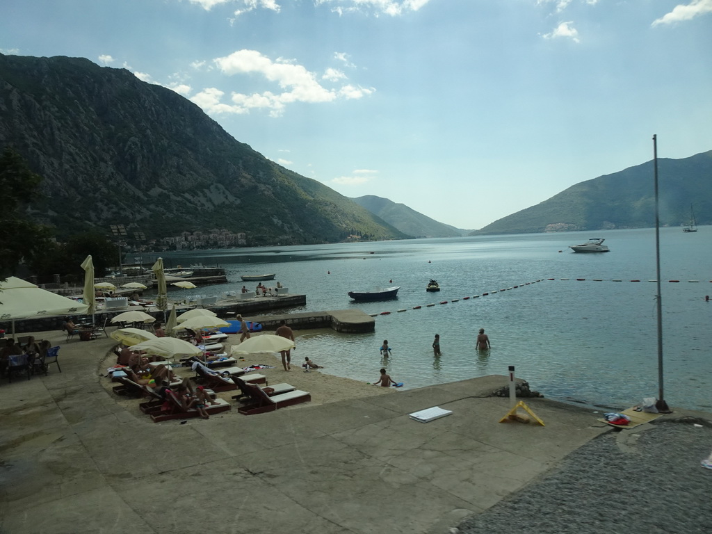 Beach at the town of Risan and boats at the Bay of Kotor, viewed from the tour bus on the E65 road