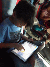 Miaomiao and Max playing with iPad at the tour bus on the E65 road at the town of Drain Vrt