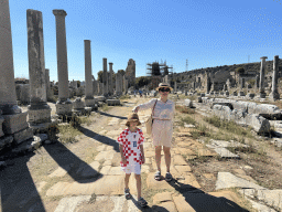 Miaomiao and Max at the south side of the Columned Main Street at the Ancient City of Perge, with a view on the Hellenistic City Gate and Towers, under renovation, and the Hadrianus Arch