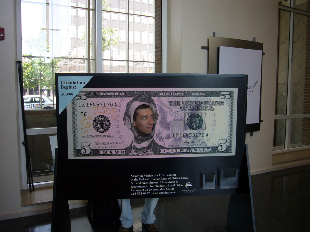 Tim in a giant 5 dollar bill in the Independence Visitor Center