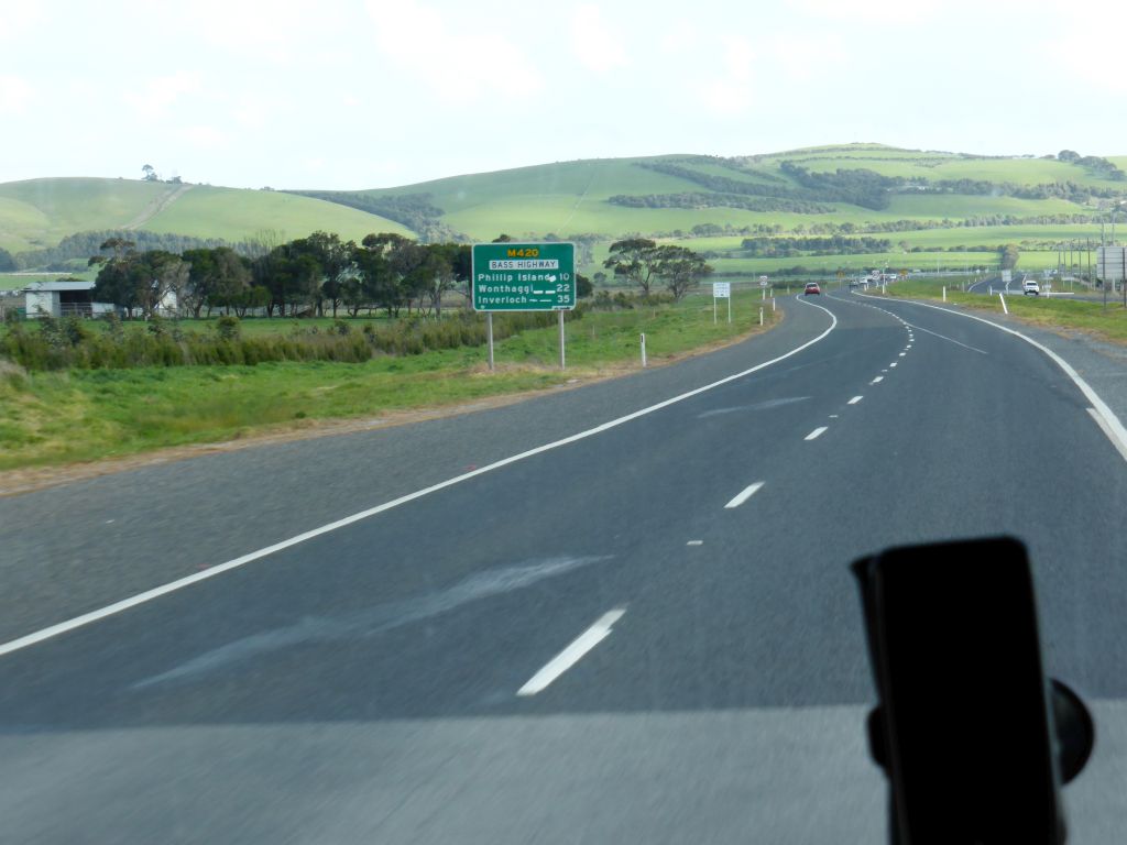 The Bass Highway and hills with grasslands, viewed from our tour bus