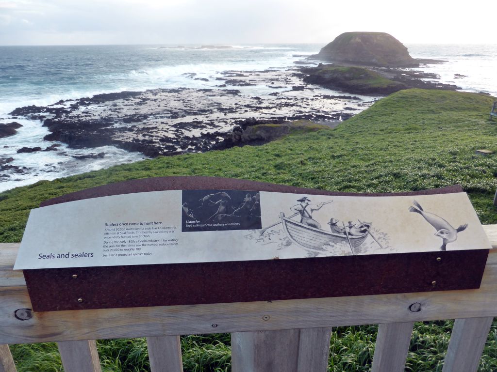 Information on seals and sealers at the Nobbies Boardwalk, with a view on the Round Island, the Seal Rocks and cliffs at the Bass Strait