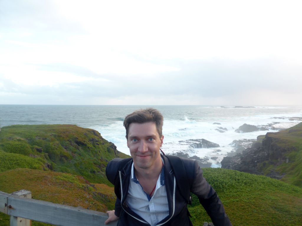 Tim at the Nobbies Boardwalk, with a view on the Seal Rocks and cliffs at the Bass Strait