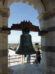 Bell at the top floor of the Leaning Tower of Pisa, with a view on the Pisa Duomo Cathedral