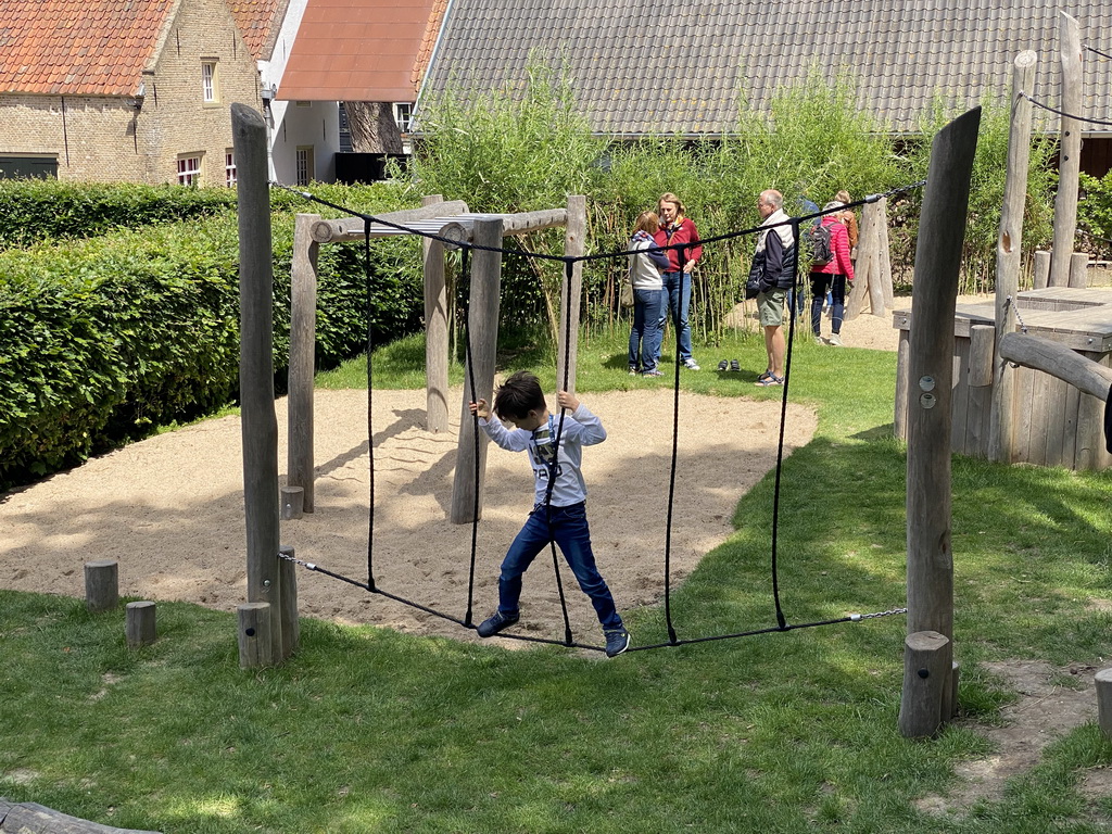 Max on a rope bridge at the playground at the main square at Loevestein Castle