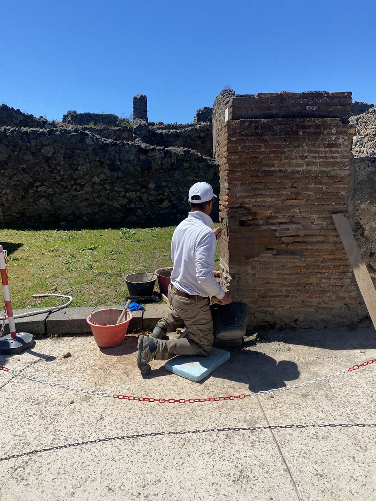 Mason renovating a wall at the Via di Mercurio street at the Pompeii Archeological Site