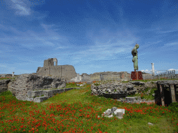 Right side of the statue of Daedalus by Igor Mitoraj at the Sanctuary of Venus and the walls of the Basilica building at the Pompeii Archeological Site