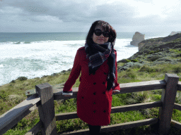 Miaomiao at the top of the Gibson Steps with a view on the cliffs at the coastline at the northwest side, with the most eastern rock of the Twelve Apostles rocks