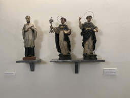 Statuettes of Saint Luís Gonzaga, Saint Tomás de Aquino and Saint Vicente Ferreira at the museum of the Igreja de Santo Ildefonso church, with explanation