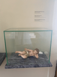 Statuette `Baby Jesus lying` at the museum of the Igreja de Santo Ildefonso church, with explanation