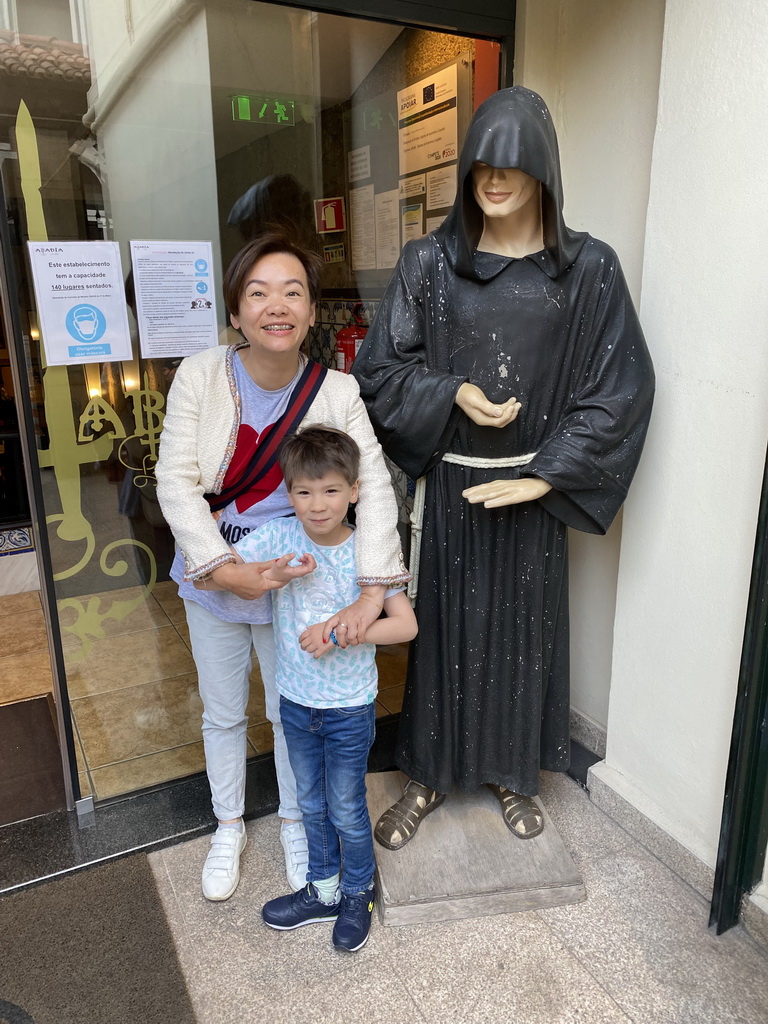 Miaomiao and Max with a statue in front of the Abadia do Porto restaurant at the Rua do Ateneu Comercial do Porto street