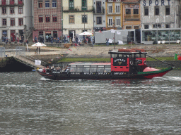 Boat on the Douro river and Vila Nova de Gaia, viewed from the Cais da Estiva street