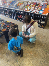 Miaomiao and Max playing with a spinning top at the SOL Artesanato Handcraft store