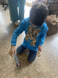 Max playing with a spinning top at the SOL Artesanato Handcraft store