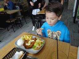 Max eating fish and chips at the Grupo Desportivo Infante D. Henrique restaurant