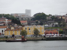 Boat on the Douro river and Vila Nova de Gaia with the Gaia Cable Car, viewed from the Cais da Estiva street